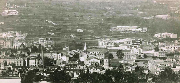 Vista del barri del Mercadal des d'un indret enlairat. Hi destaquen la Torre de les Aigües i el campanar neogòtic de l'església de Santa Susanna. 1925-1936