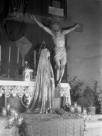 Crist crucificat amb la imatge de la Mare de Déu a l'altar de l'església. 1930-1940