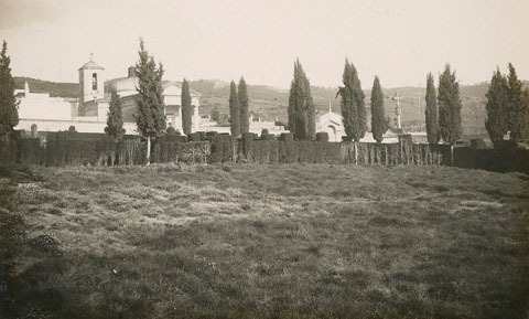 Vista del cementiri de Girona. A l'esquerra s'observa el campanar de l'església, i a la dreta la creu de terme. 1932