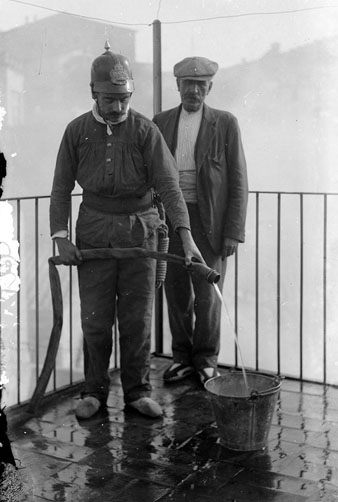 Bomber treballant en un terrat acompanyat per un altre home. 1900-1930