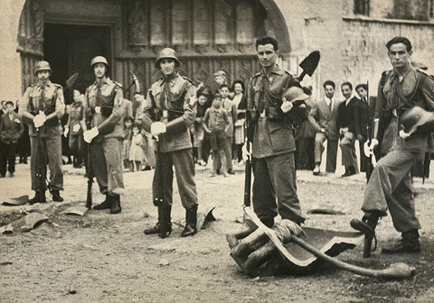 Plaça dels Apòstols de la Catedral de Girona. Militars al voltant de les restes de la campana Assumpta després de caure des del campanar durant la processó de Corpus. 20 de juny de 1946