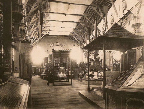 Interior del pavelló dedicat a Girona a l'Exposició Universal de Barcelona. Al centre s'identifica una campana de l'empresa Barberí d'Olot. 1888