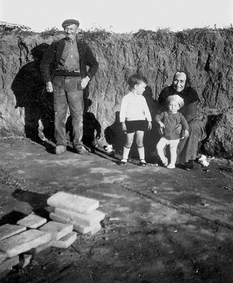 Josep Serra i Carolina jugant amb els seus nets Josep i Montserrat Campins Serra a la bòbila Serra, al barri de Palau-sacosta. 1932