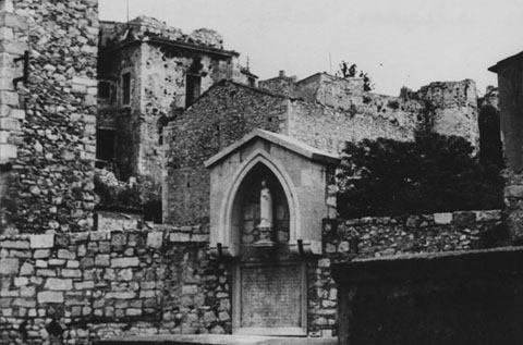 Imatge de Sant Vicenç Ferrer, obra de l'escultor Francesc Bacquelaine i Carreras instal·lada a la plaça Sant Domènec. A l'esquerra, l'edifici de les Àliguesligues. Ca. 1965