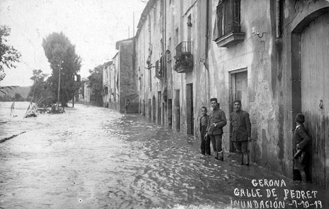 Vista del carrer Pedret inundat pel desbordament del riu Ter. Al fons sobresurt l'església del Pilar. 7 d'octubre 1919