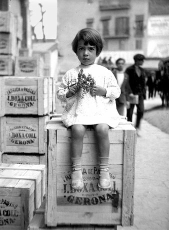 Retrat de Rosa Boxa sobre una de les caixes de pasta de la fàbrica Boxa, a la plaça Marquès de Camps. 1931