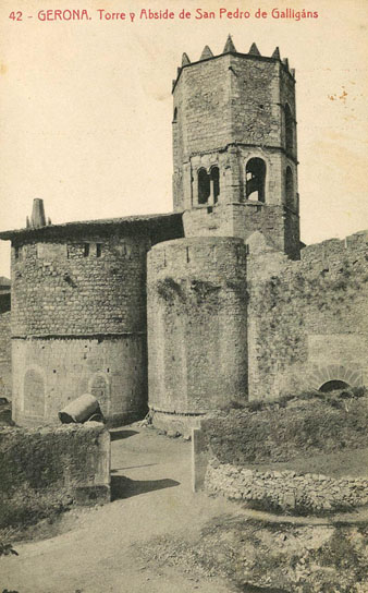 Vista de la capçalera de lesglésia de Sant Pere de Galligants i del portal de Sant Pere des de lantic cam de Monjuïc. S'hi observa el desaparegut portal de Sant Pere. 1906-1911
