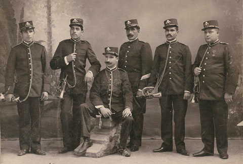 Retrat d'estudi de la Companyia Municipal de Bombers amb els seus uniformes de gala i cornetes. 1907