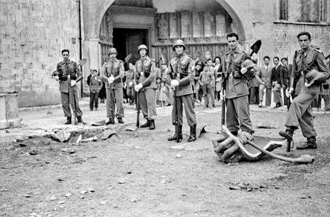 Plaça dels Apòstols de la Catedral de Girona. Militars al voltant de les restes de la campana Assumpta després de caure des del campanar durant la processó de Corpus. 20 de juny de 1946