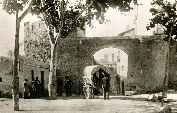 El portal i la torre del Carme. A l'esquerra, la casa dels burots, encarregats de cobrar els drets d'entrada de determinades mercaderies. 1900