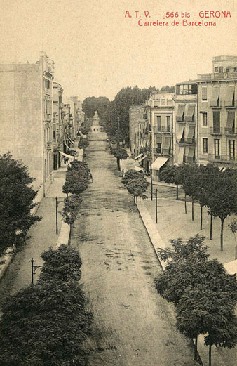 Vista des d’un punt elevat de la plaça Marquès de Camps i de la carretera de Barcelona. En segon terme a l’esquerra, el Banc d’Espanya. S’observen els plataners plantats a banda i banda del carrer. 1905-1911