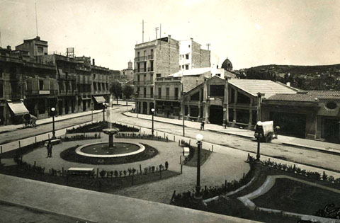 La plaça del Marquès de Camps. Al centre, el garatge Internacional, a l'esquerra, l'establiment d'alimentació Busquets. 1925-1930