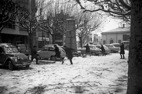 Nens jugant amb la neu a la plaça Poeta Marquina, davant l'estació de tren. Al centre, el monument als caiguts durant la Guerra Civil. 1967