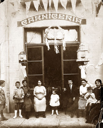 Façana d'una carnisseria a la plaça Poeta Marquina. Davant d'establiment membres de la família Met Caracas i el propietari, Joan Verderi. 1915-1918