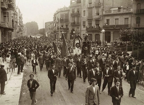 Visita del president Francesc Macià a Girona. La comitiva, encapçalada per banderes i estandards, passant per la plaça Marquès de Camps. 21/06/1931
