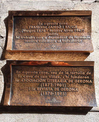 Plaques commemoratives de l'estada de Francesc Cambó i de les tertúlies de la 'Cova de can Viñas' a la façana de la casa número 2 del carrer dels Abeuradors