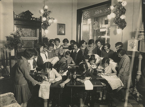Dones cosint amb màquines de la marca Singer a l'interior del local del carrer Abeuradors cantonada carrer Mercaders. 1926