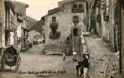 Vista de la plaça d'Osor. En primer terme s'observa una tartana en un racó de la plaça. 1918