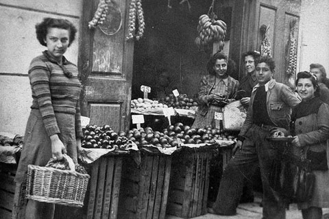 Grup de clients a l'exterior de la fruiteria de Can Turró, al carrer Hortes. 1940