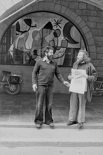Retrat dels artistes Enric Ansesa i Damià Escudé, a l'exterior de la Fontana d'Or, al carrer Ciutadans, mostrant la portada del diari Avui reclamant l'Estatut. 1977