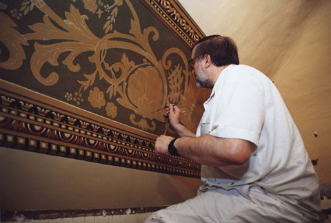 Ricard Renart treballant en les tasques de restauració de les pintures murals de l'antic menjador del restaurant de l'Hotel Centre de Girona, posteriorment dependències de l'Ajuntament de Girona. 1980