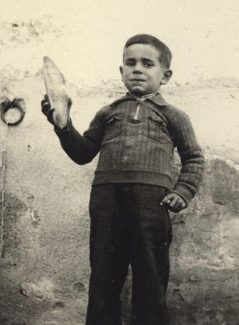 Retrat d'un nen amb una barra de pa a les mans. 1936