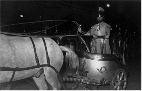La biga a la desfilada del Xè aniversari, el Dimecres Sant de l’any 1950, a la plaça del Vi, amb l’auriga Ricard Fina arriant els cavalls per emprendre la pujada del Pont de Pedra