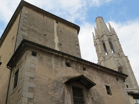 El campanar de la basílica de Sant Feliu des de la façana nord. En primer terme, capelleta dedicada a Sant Narcís
