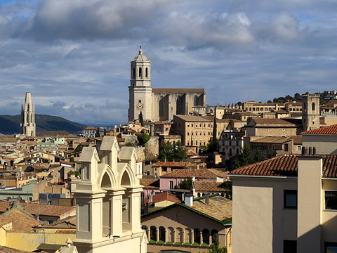 Vista dels teulats de Girona des del tram de muralla. En primer terme, el centre Maria Gay, i al fons, Sant Feliu i la Catedral