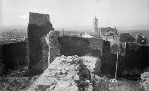 Vista d'un tram de la muralla de Sant Domènec des de les restes de Torre Gironella. A l'esquerra, la torre del Telègraf, coneguda també com a torre del Llamp i les restes de la caserna d'Alemanys. 1930-1940