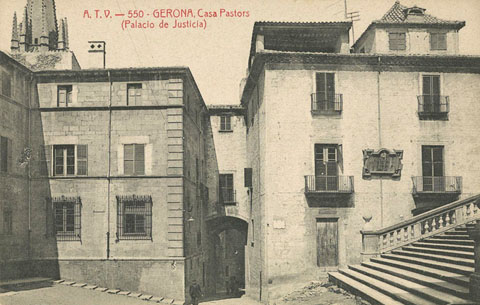 Vista del portal de Sobreportes des de la plaça de la Catedral. En primer terme a l'esquerra, la Casa Pastors, posteriorment seu del palau de Justícia i a la dreta, el convent del Cor de Maria. S'observen les obres de construcció dels ressoladors de les escales de la Catedral de Girona. 1904