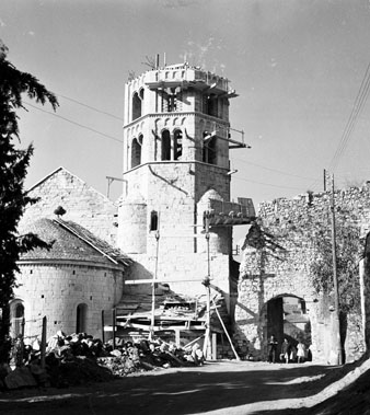 Campanar i absis de l'església de Sant Pere de Galligants en obres. A la dreta el portal de Sant Pere que donava accés a la Vall de Sant Daniel. 1960