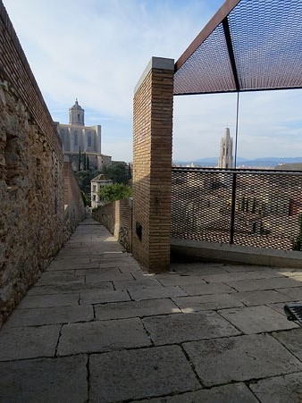 Camí de ronda de la muralla de Santa Llúcia. Al fons, la Catedral i el campanar de Sant Feliu