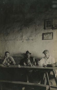 Retrat de tres homes a l'interior d'un menjador, al santuari de la Mare de Déu del Far. 1920